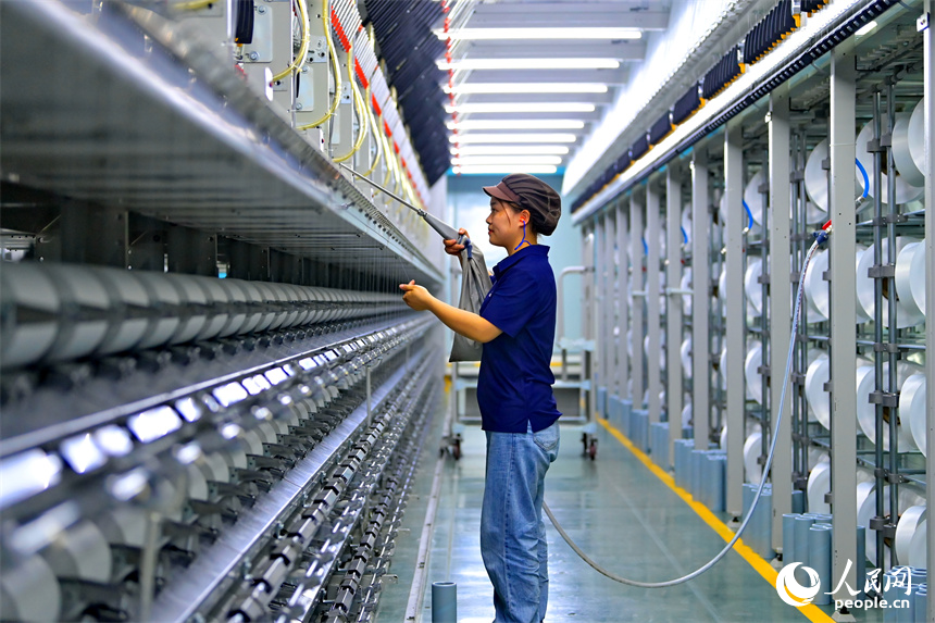 瑞金市的一家化纖紡織企業，工人在生產線上趕制出口東南亞國家的產品訂單。人民網 朱海鵬攝