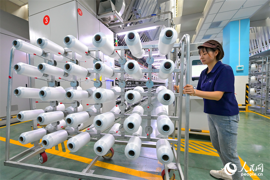 瑞金市的一家化纖紡織企業，工人在生產線上趕制出口東南亞國家的產品訂單。人民網 朱海鵬攝