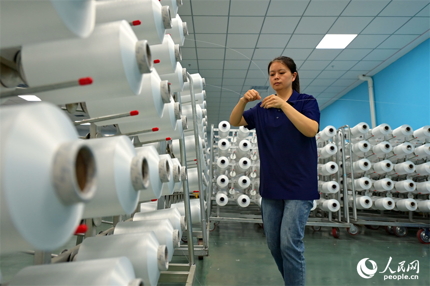 瑞金市的一家化纖紡織企業，工人在生產線上趕制出口東南亞國家的產品訂單。人民網 朱海鵬攝