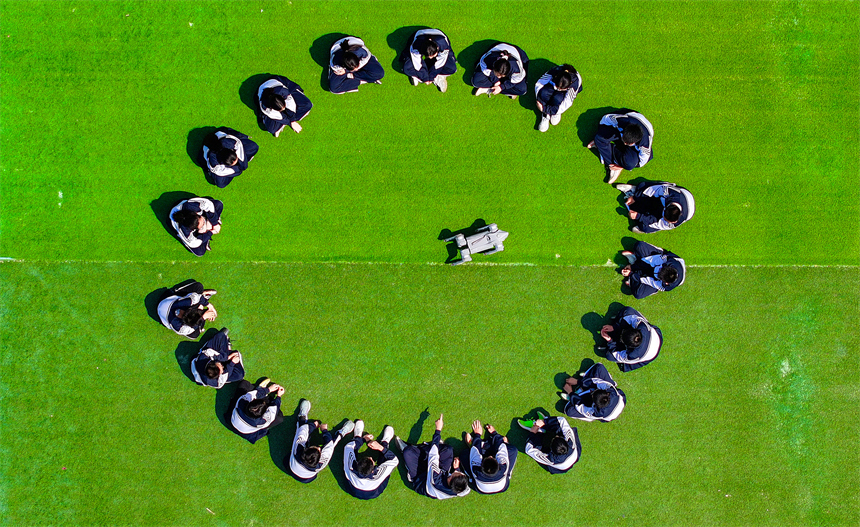 大課間活動時，學生們正在與機器狗進行“人機互動”。郭昊攝