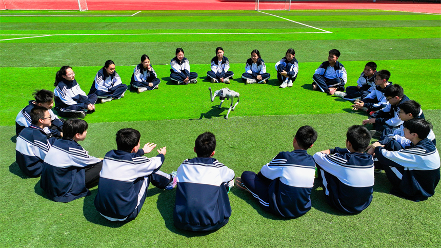 大課間活動時，學生們正在與機器狗進行“人機互動”。郭昊攝