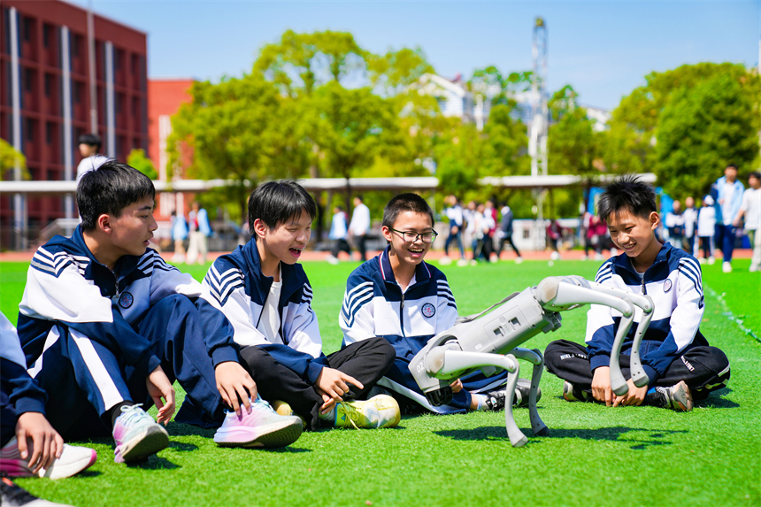 大課間活動時，學生們正在與機器狗進行“人機互動”。郭昊攝
