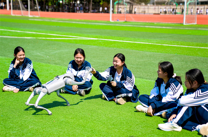 大課間活動時，學生們正在與機器狗進行“人機互動”。郭昊攝