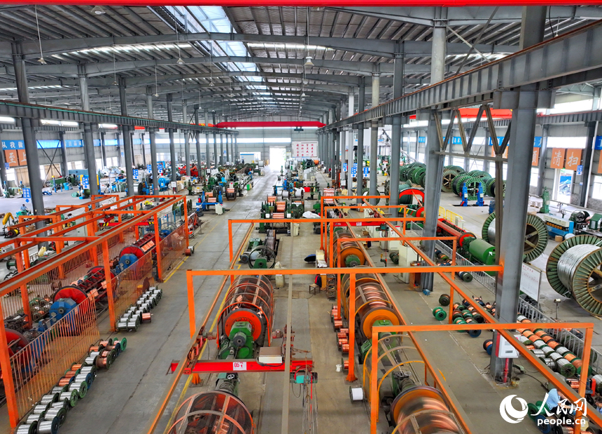 瑞金市經濟開發區的一家電線電纜企業智能制造車間內，工人在生產線上趕制出口的銅線訂單產品。人民網 朱海鵬攝