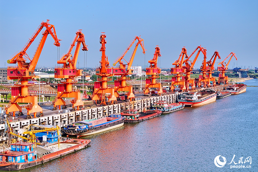 南昌市南昌縣富山鄉贛江河畔，姚灣綜合碼頭船來船往，裝卸運輸設備有序運轉，一派繁忙景象。人民網 朱海鵬攝