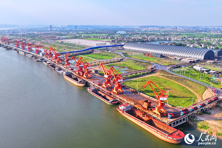 南昌市南昌縣富山鄉贛江河畔，姚灣綜合碼頭船來船往，裝卸運輸設備有序運轉，一派繁忙景象。人民網 朱海鵬攝