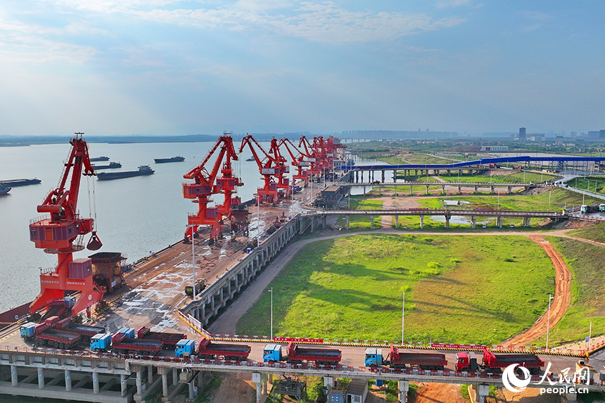 南昌市南昌縣富山鄉贛江河畔，姚灣綜合碼頭船來船往，裝卸運輸設備有序運轉，一派繁忙景象。人民網 朱海鵬攝