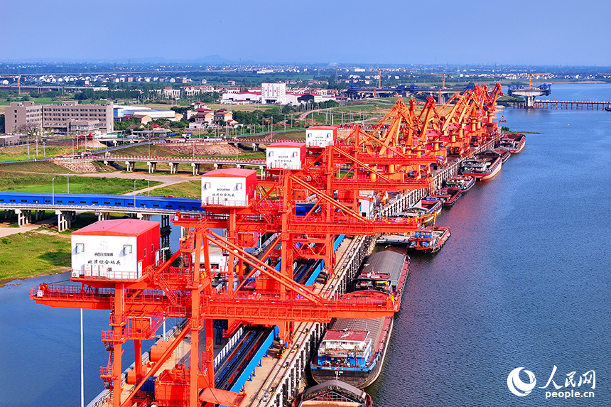 南昌市南昌縣富山鄉贛江河畔，姚灣綜合碼頭船來船往，裝卸運輸設備有序運轉，一派繁忙景象。人民網 朱海鵬攝