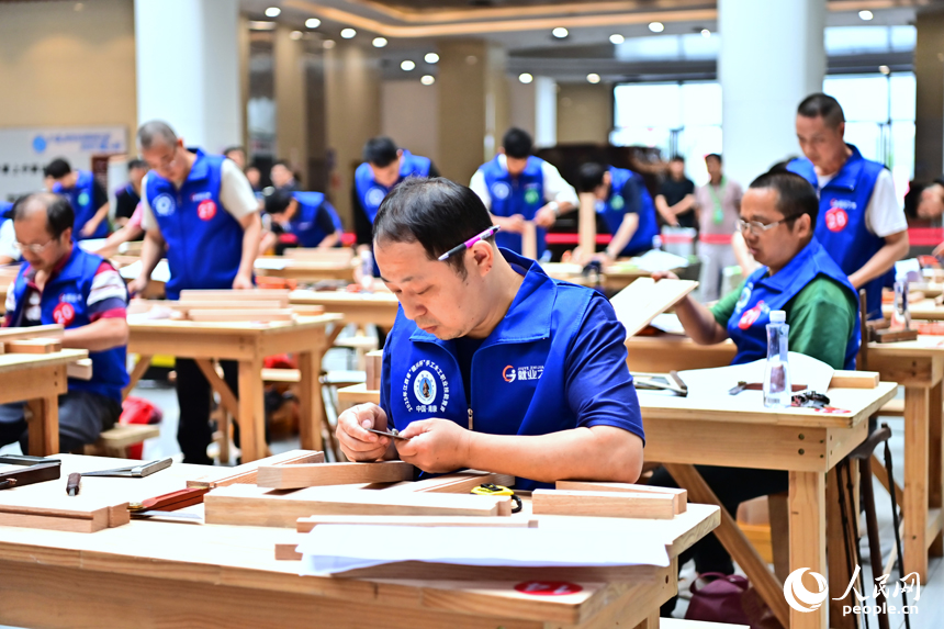贛州市南康區家居小鎮博覽中心，幾十名木匠工人在手工木工（木制家具工）職業技能競賽決賽中制作家具。人民網 朱海鵬攝