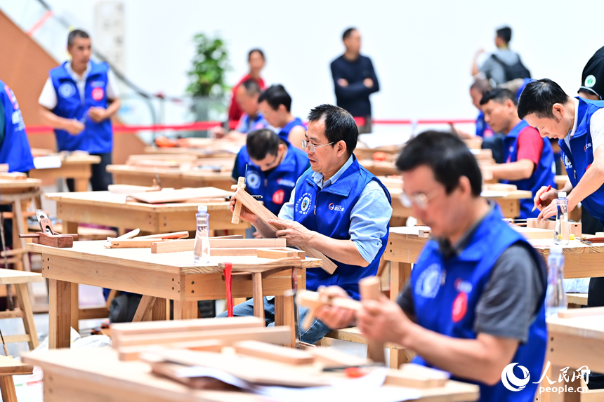 贛州市南康區家居小鎮博覽中心，幾十名木匠工人在手工木工（木制家具工）職業技能競賽決賽中制作家具。人民網 朱海鵬攝