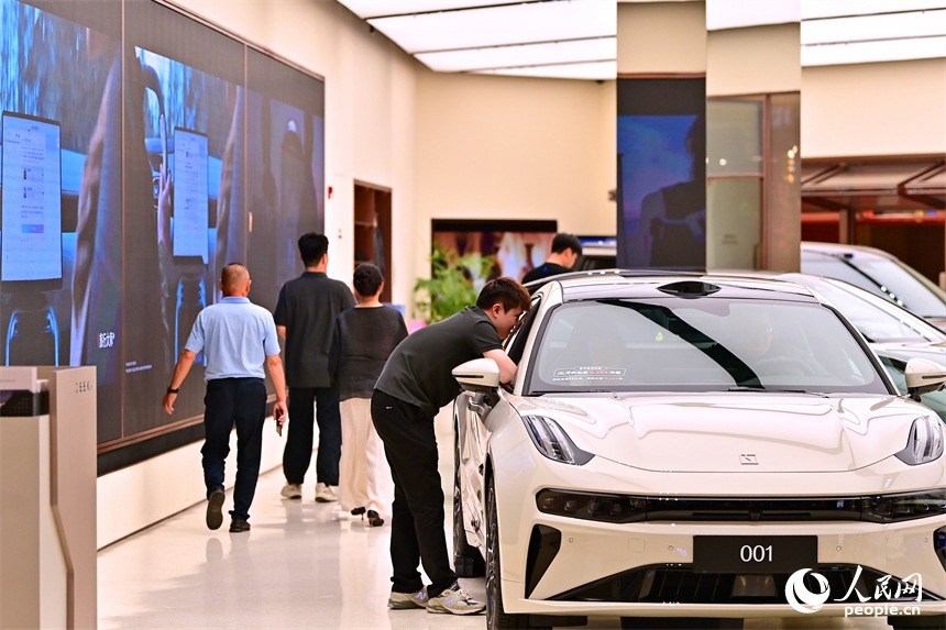 顧客在了解選購車型，咨詢汽車“以舊換新”補貼政策。人民網 朱海鵬攝