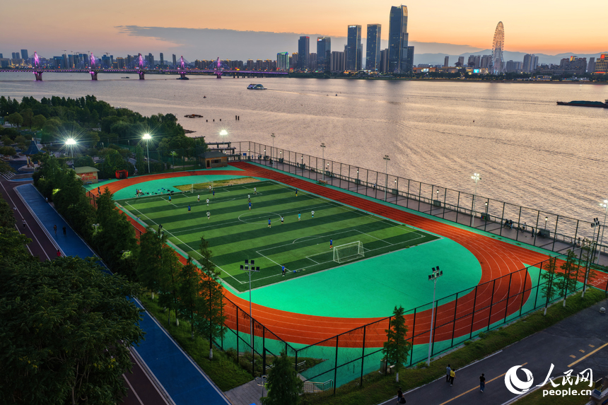 市民們在南昌市贛江畔的體育公園里踢足球。人民網記者 毛思遠攝