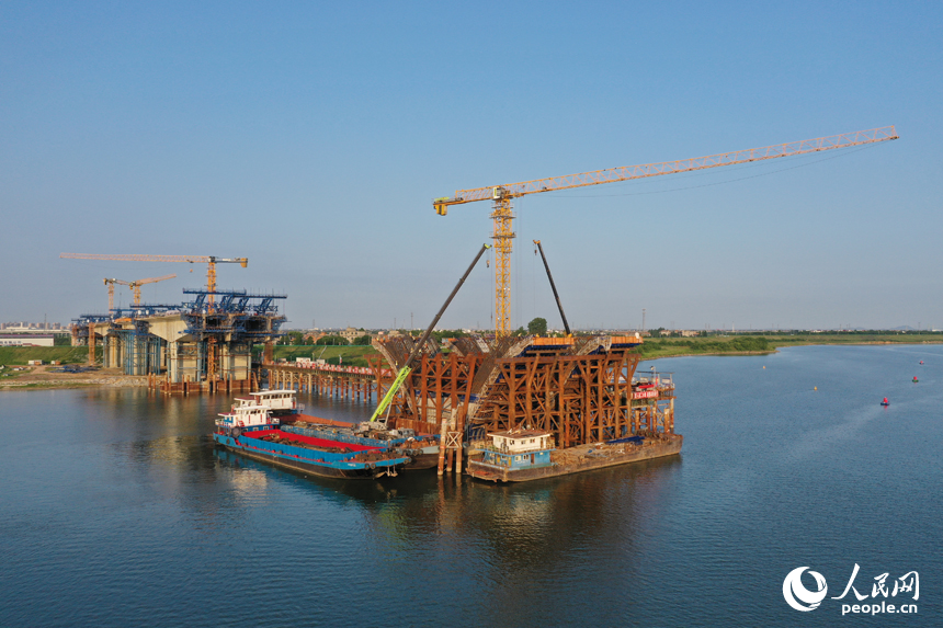 昌南大橋的施工現場塔吊林立，施工人員在汛期搶抓工期，為大橋建設按下“快進鍵”。人民網記者 時雨攝