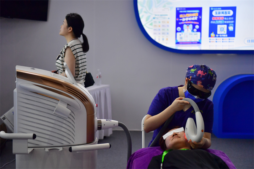 在國際大健康產業大會暨博覽會上，醫生為患者進行診療體驗。人民網記者 時雨攝