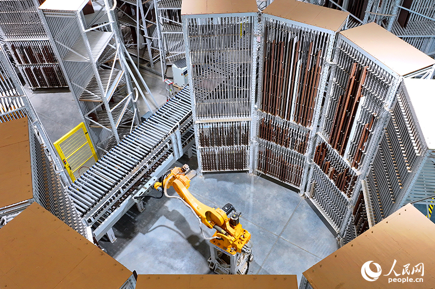 智能制造企業車間內，智能機器人手臂快速運轉，板材分揀包裝有序進行。人民網 朱海鵬攝