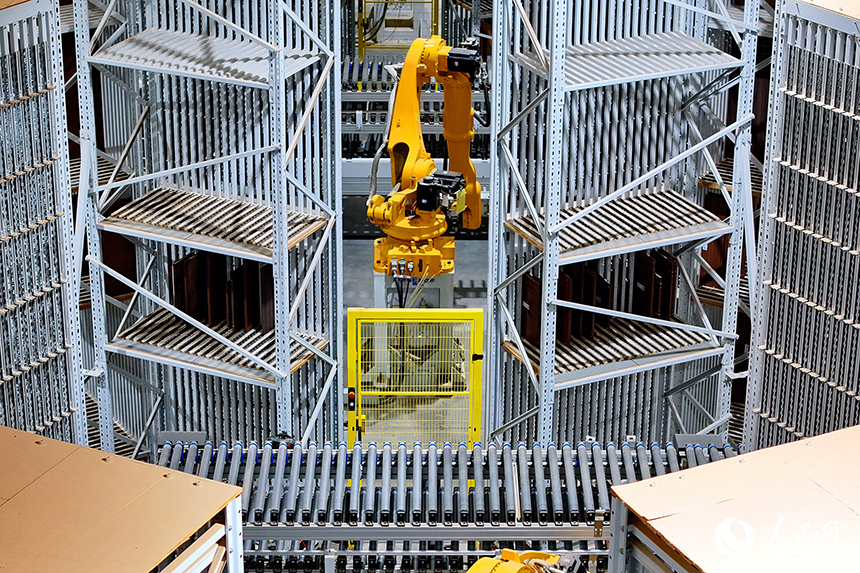 智能制造企業車間內，智能機器人手臂快速運轉，板材分揀包裝有序進行。人民網 朱海鵬攝