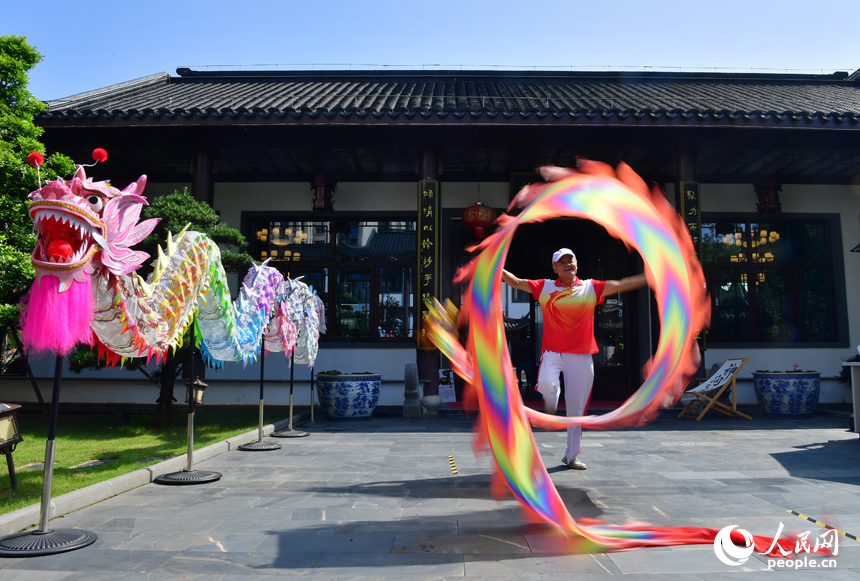 一名非物質文化遺產代表性傳承人正在集市現場舞龍。人民網記者 時雨攝