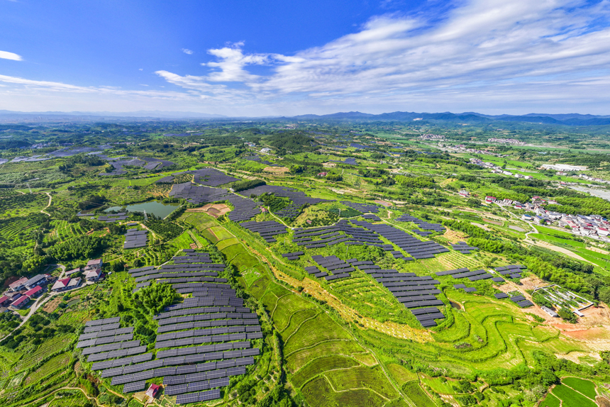 南豐縣桑田鎮古城村，鱗次櫛比的太陽能光伏板與青山綠樹、村莊田園相互映襯，大地猶如披上藍色“外衣”。謝東攝