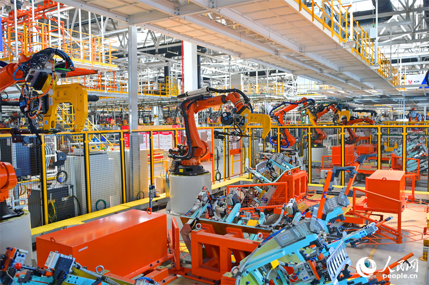 江鈴汽車富山工廠數字化車間內，智能焊裝機械臂有序運轉，工人在生產線上忙碌。人民網 朱海鵬攝