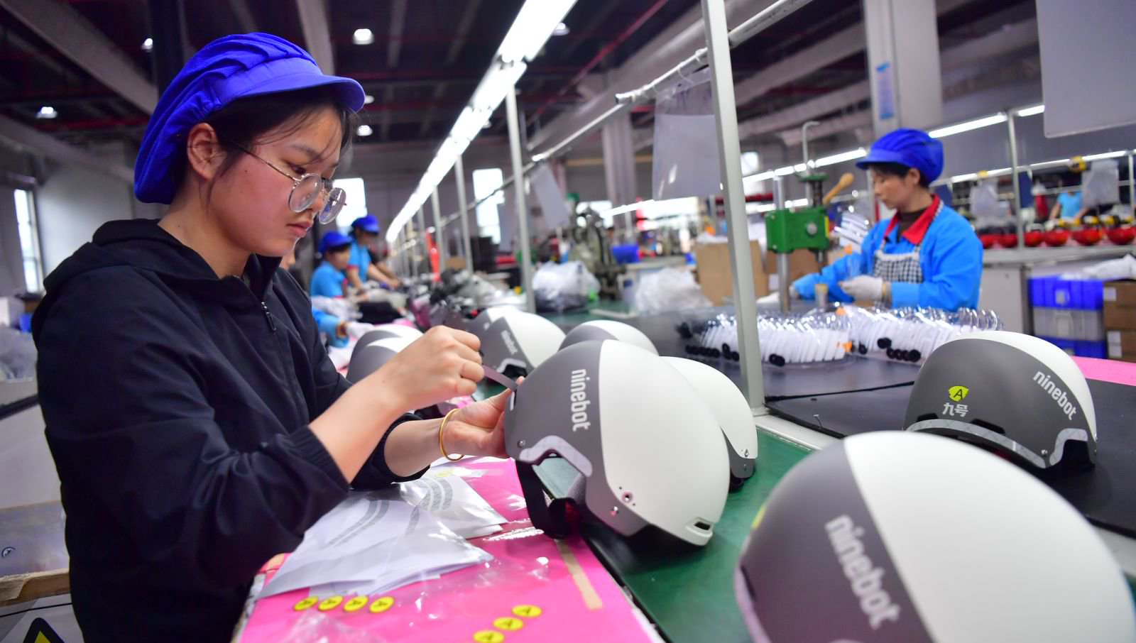 贛州溢聯科技有限公司的車間內，工人們正在生產兒童頭盔。
