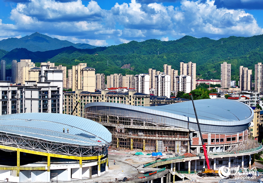 贛州市石城縣西城體育中心項目建設現場，工人在安裝體育館鋼結構屋面網架和頂棚。人民網 朱海鵬攝