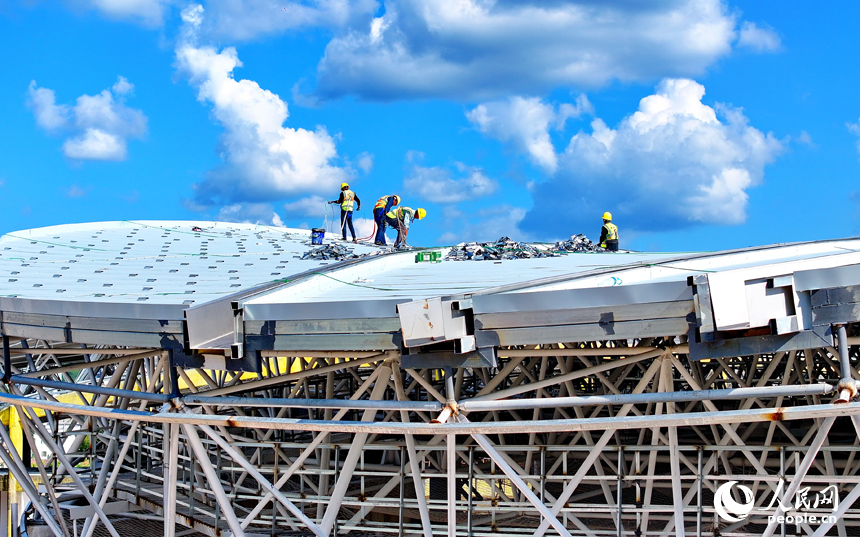贛州市石城縣西城體育中心項目建設現場，工人在安裝體育館鋼結構屋面網架和頂棚。人民網 朱海鵬攝