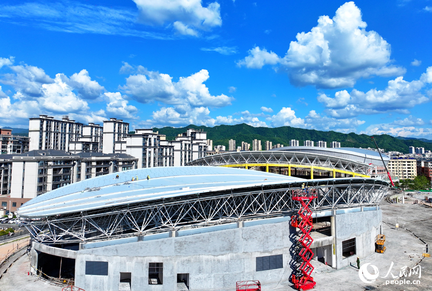 贛州市石城縣西城體育中心項目建設現場，工人在安裝體育館鋼結構屋面網架和頂棚。人民網 朱海鵬攝