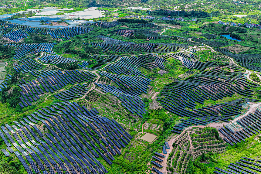 鱗次櫛比的光伏組件分布在荒山坡上，與延綿群山相映相襯，構成一道獨特的風景線。李煜祖攝
