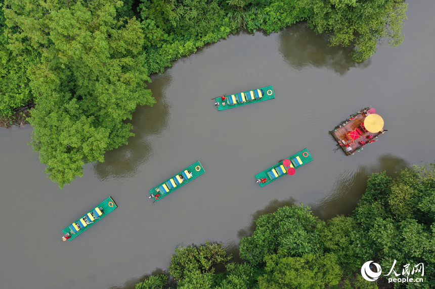 廣昌縣楊溪鄉撫河源的河道里游客們乘坐竹筏，享受盛夏里的清涼和愜意。人民網記者 時雨攝