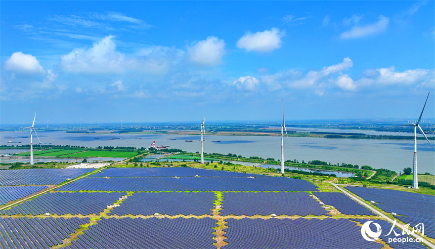 九江市彭澤縣帽子山風光電站，連片的光伏發電板與風力發電機組相得益彰，源源不斷地輸送清潔能源。人民網 朱海鵬攝