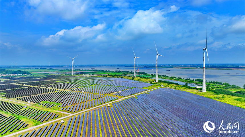 九江市彭澤縣帽子山風光電站，連片的光伏發電板與風力發電機組相得益彰，源源不斷地輸送清潔能源。人民網 朱海鵬攝