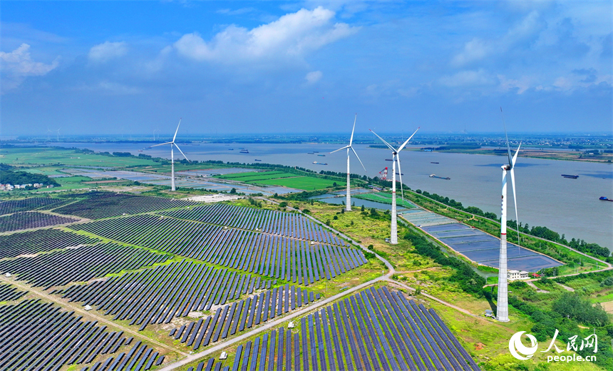 九江市彭澤縣帽子山風光電站，連片的光伏發電板與風力發電機組相得益彰，源源不斷地輸送清潔能源。人民網 朱海鵬攝