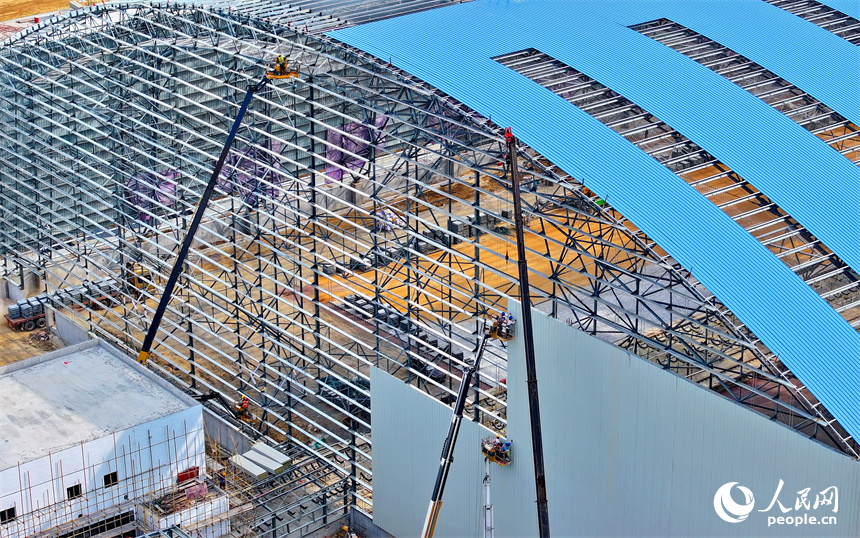建設者們冒著高溫在高空進行貨棚擋板安裝作業。人民網 朱海鵬攝