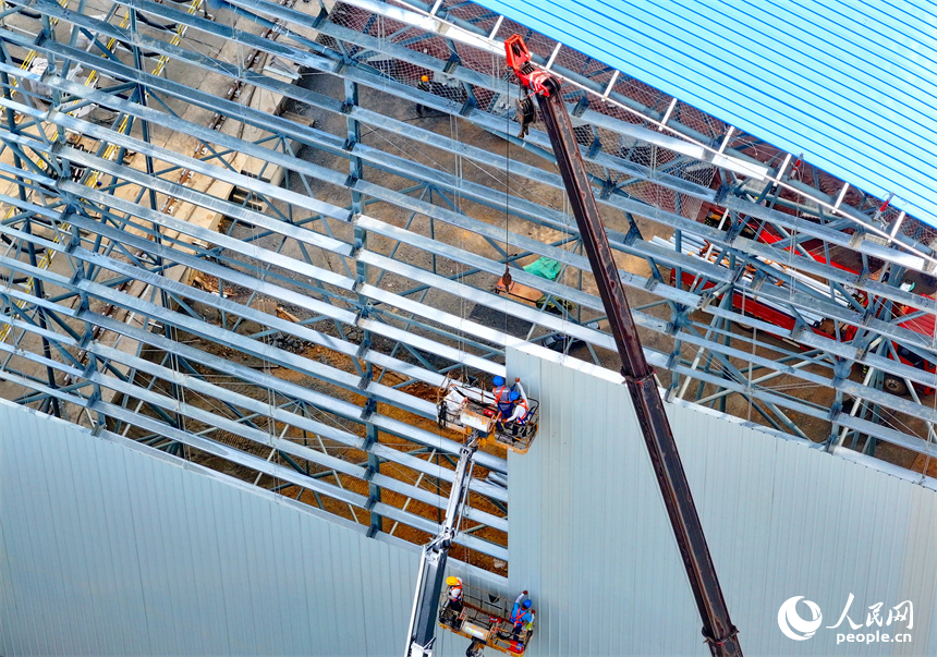 建設者們冒著高溫在高空進行貨棚擋板安裝作業。人民網 朱海鵬攝