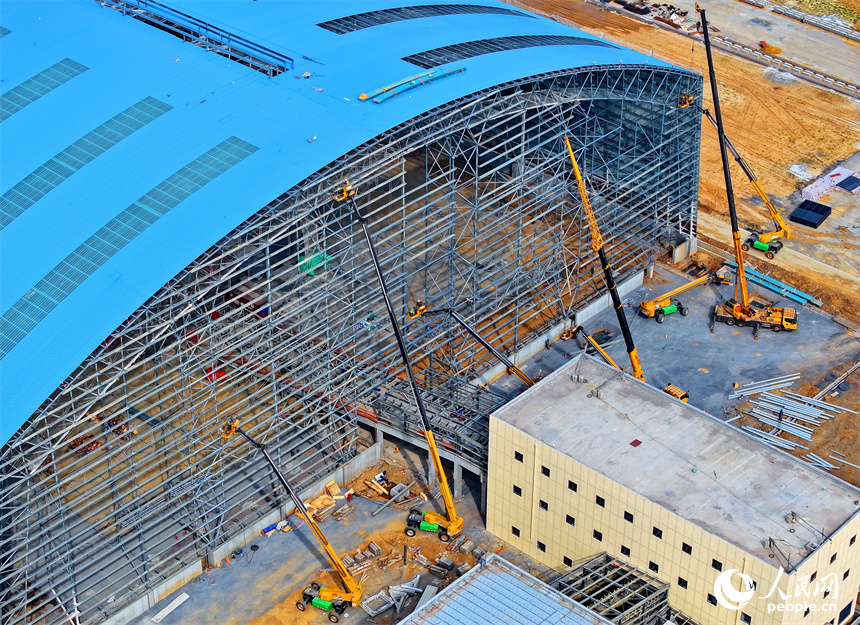 建設者們冒著高溫在高空進行貨棚擋板安裝作業。人民網 朱海鵬攝