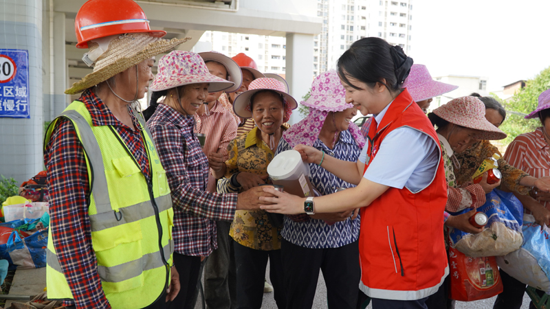 贛州北站“水清班組”志愿者為養護工人送涼茶。唐琳攝