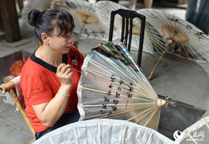 古祠堂內，村民正在制作油紙傘。人民網記者 時雨攝