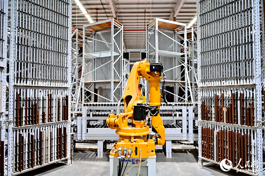 贛州市南康區國際家居總部經濟區的一家企業全屋整裝智能制造車間內，工人在操作智能機器人手臂裁切家具板材。人民網 朱海鵬攝