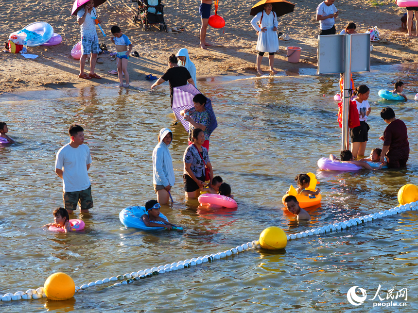 市民游客在南昌市摩天灣天然泳場消暑納涼。人民網記者 毛思遠攝