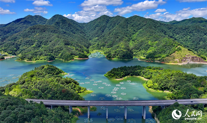 贛州市尋烏縣三標鄉東江源村，尋全高速車輛穿村而過，群山碧水與藍天白云相映襯，構成一幅水清岸綠景美的生態畫卷。人民網 朱海鵬攝