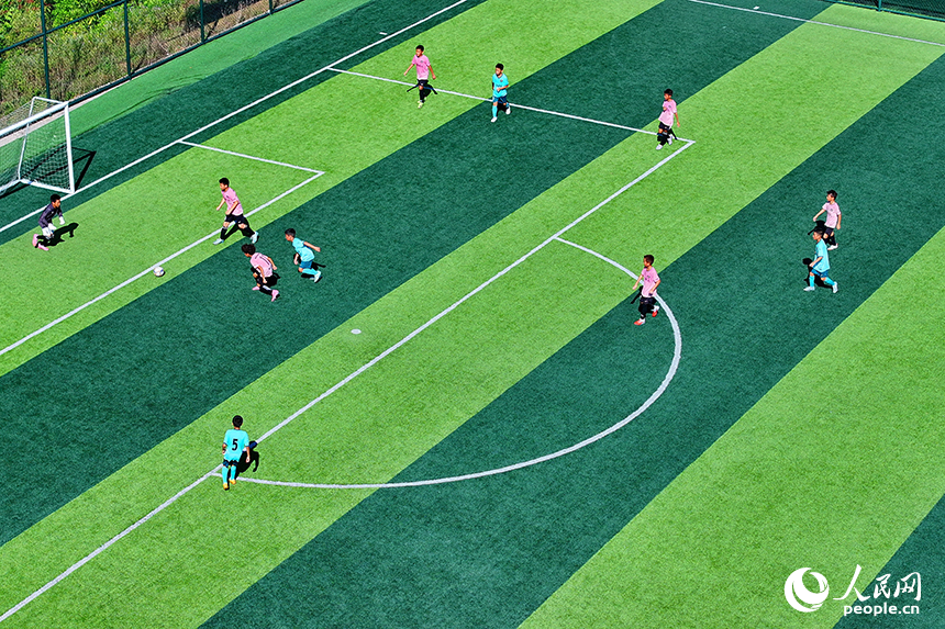 江西定南（國家）青少年足球訓練中心，各地前來參加夏季訓練營的足球小將們在場上訓練、比賽。人民網 朱海鵬攝