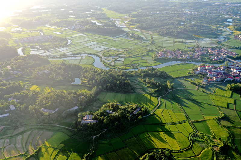 上高縣新界埠鎮五星村，夕陽與田壟、公路、民居、河流構成一幅田園風光畫。陳旗海攝
