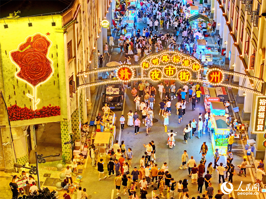 贛州市陽明路標準鐘夜市街，人頭攢動、熙熙攘攘，許多游客在逛夜市、吃小吃。人民網 朱海鵬攝
