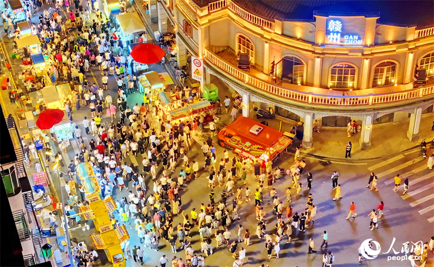 贛州市陽明路標準鐘夜市街，人頭攢動、熙熙攘攘，許多游客在逛夜市、吃小吃。人民網 朱海鵬攝