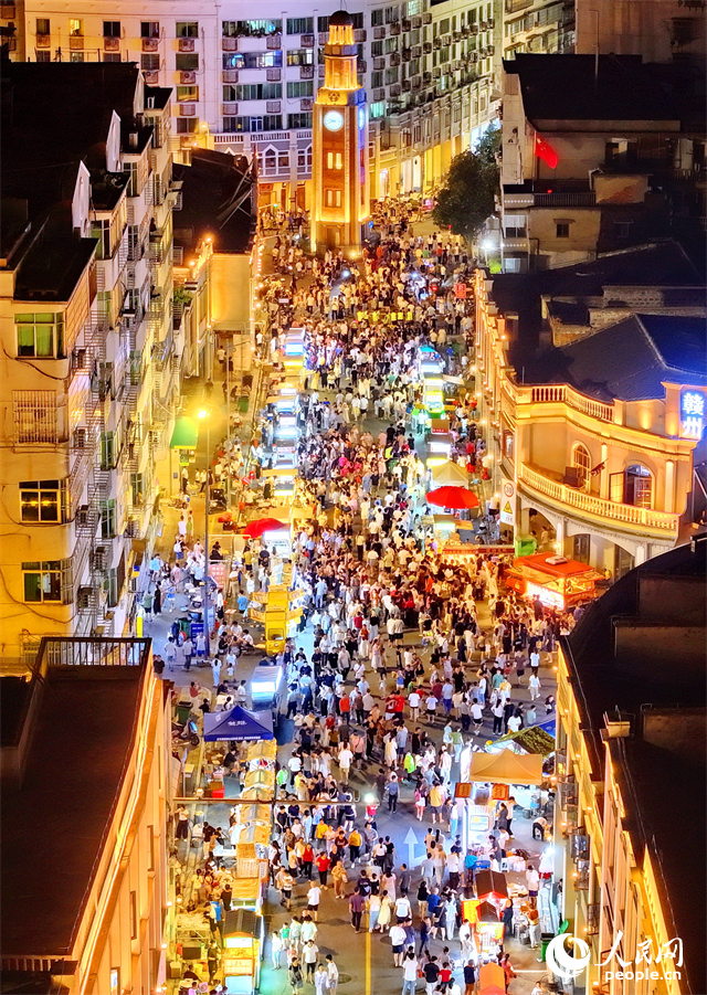 贛州市陽明路標準鐘夜市街，人頭攢動、熙熙攘攘，許多游客在逛夜市、吃小吃。人民網 朱海鵬攝