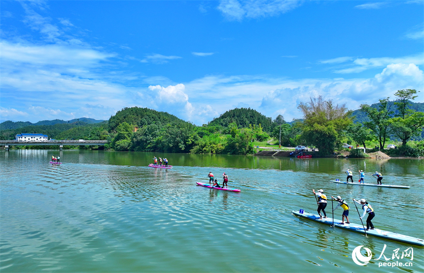 贛州市崇義縣過埠鎮的贛州小漓江，許多槳板運動愛好者在水上劃行競技。人民網 朱海鵬攝