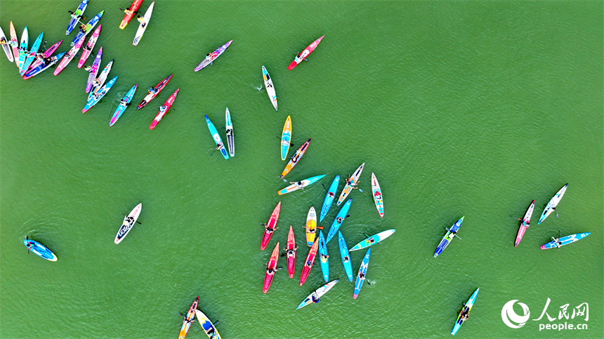 贛州市崇義縣過埠鎮的贛州小漓江，許多槳板運動愛好者在水上劃行競技。人民網 朱海鵬攝