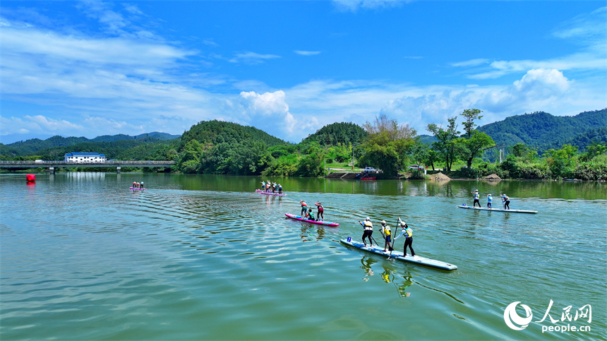 贛州市崇義縣過埠鎮的贛州小漓江，許多槳板運動愛好者在水上劃行競技。人民網 朱海鵬攝