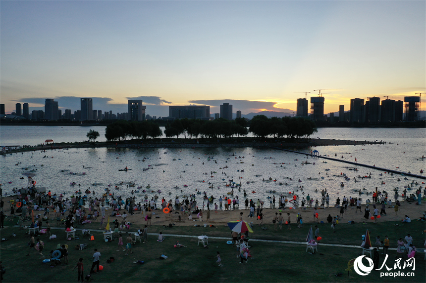 市民和游客在萬紫千紅灘的天然泳場戲水納涼。人民網記者 時雨攝