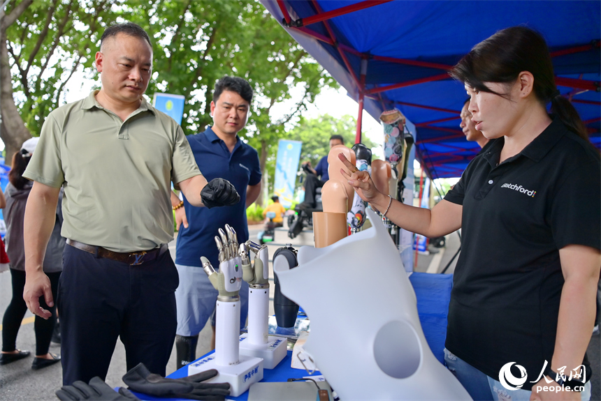 參觀者在科技助殘展區咨詢試用智能假肢產品。人民網 朱海鵬攝